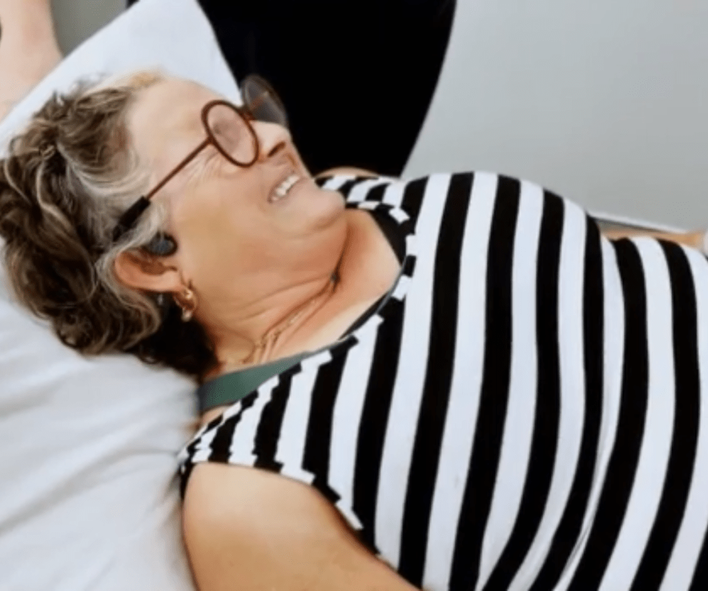 Julie lies in bed in pain.